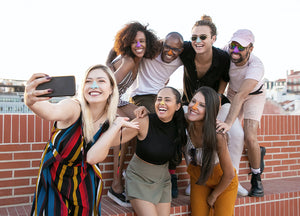 group of friends on a rooftop taking a picture with Nöz sunscreen  