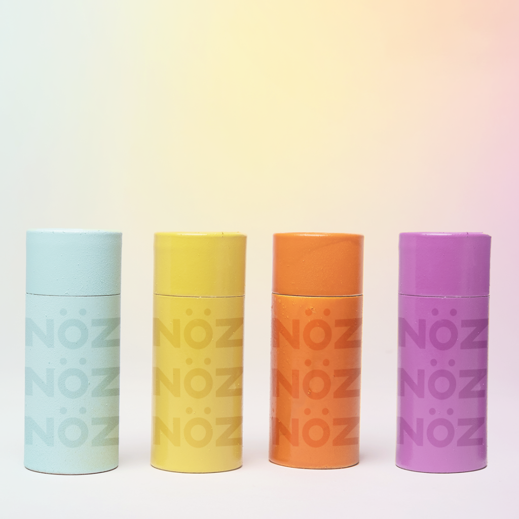 Four different color of Nöz sunscreen stick blue, yellow, orange, and purple