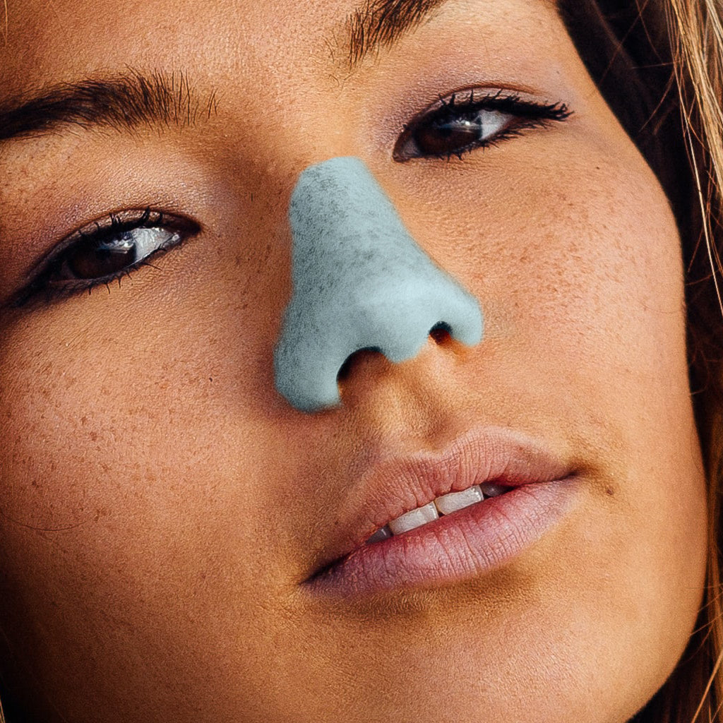 close up on woman face with blue Nöz sunscreen on nose 